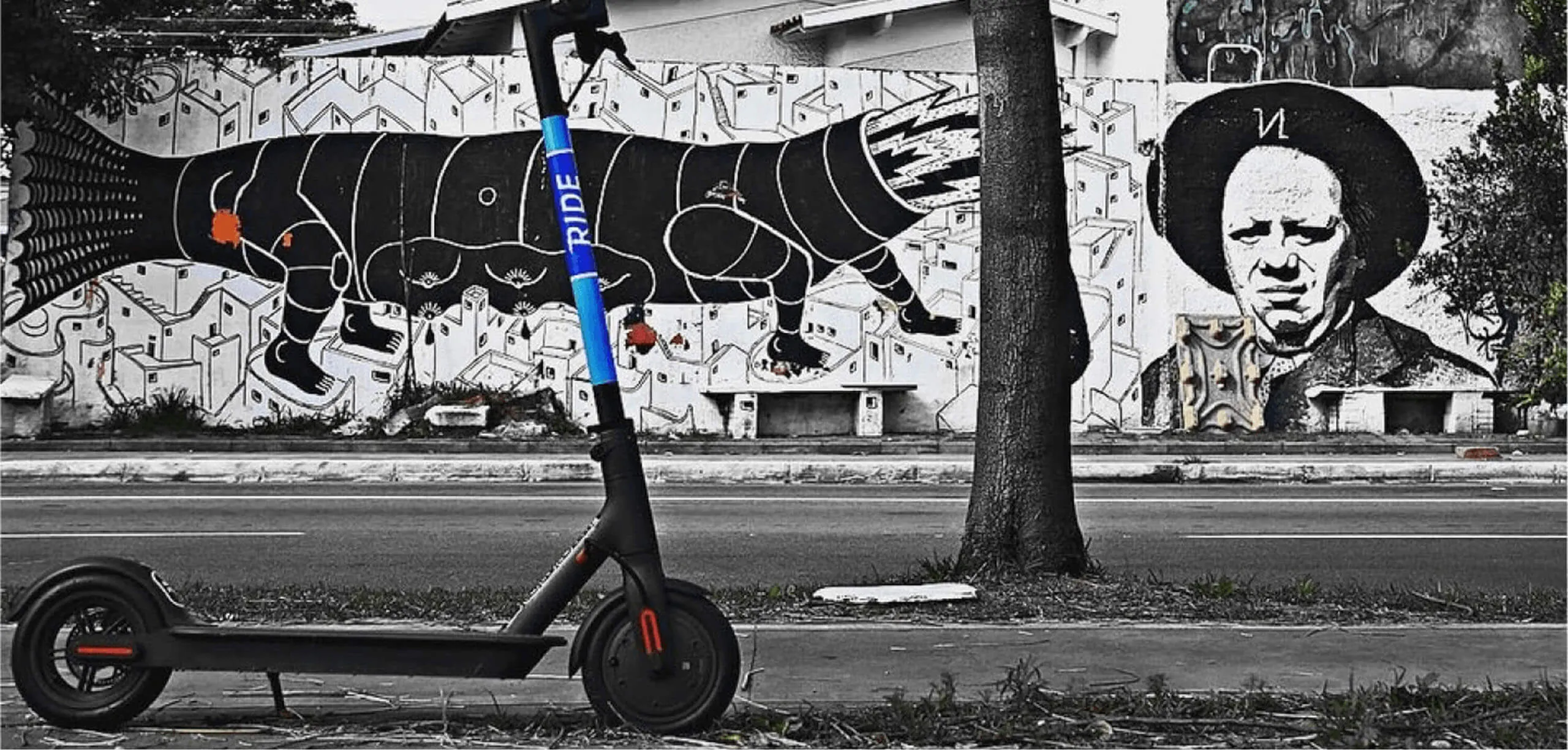 Scooter elétrica da Ride diante de um muro grafitado